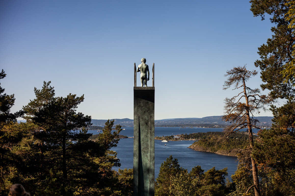 Skulptur med en gutt på et veldig høyt stupebrett, titter ned - Oslofjorden foran han. FOTO